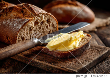 Fresh butter topping homemade bread with a butter knife 130370452