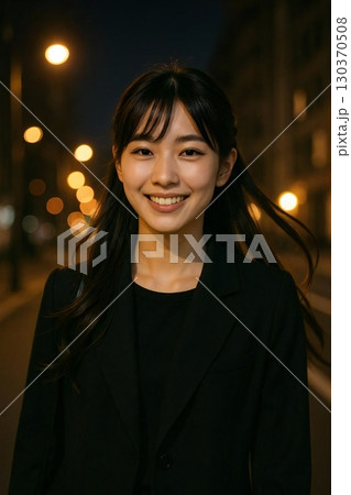 夜の街灯に照らされながら歩き、髪が光を反射する長髪の美しい日本人女性 130370508