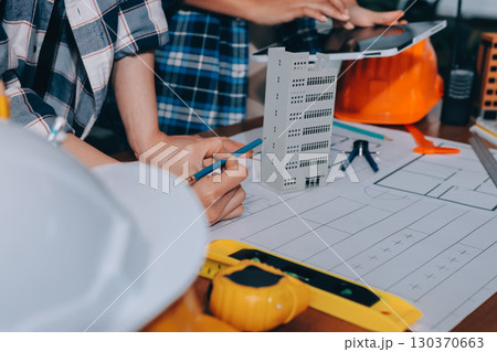 Construction and structure concept of engineer working drawing on blueprint meeting for project working with partner on model building and engineering tools in working site, construction concept. 130370663