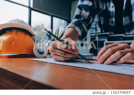 Construction and structure concept of engineer working drawing on blueprint meeting for project working with partner on model building and engineering tools in working site, construction concept. 130370697