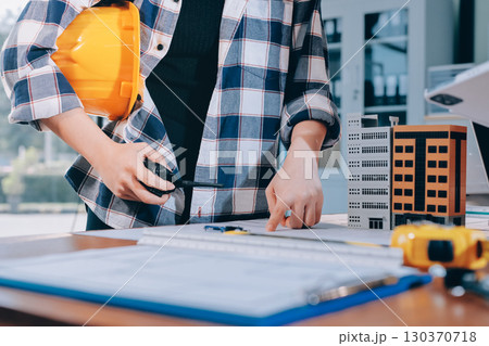Construction and structure concept of engineer working drawing on blueprint meeting for project working with partner on model building and engineering tools in working site, construction concept. 130370718
