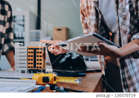 Construction and structure concept of engineer working drawing on blueprint meeting for project working with partner on model building and engineering tools in working site, construction concept. 130370719