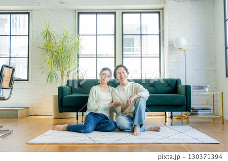 リビングでくつろぐミドルの夫婦 リビングでくつろぐミドルの夫婦 130371394