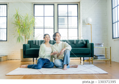 リビングでくつろぐミドルの夫婦 リビングでくつろぐミドルの夫婦 130371395