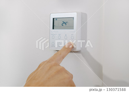 man turning on or off the air conditioning 130371588