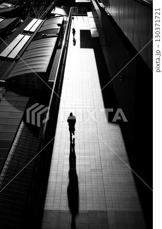 長く伸びる影と歩く人のシルエット 〜都市の静寂と時間〜 長く伸びる影と歩く人のシルエット 〜都市の静寂と時間〜 130371721
