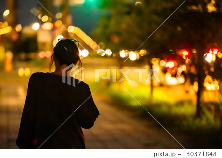 女性ひとり夜の歩道を歩いている 130371848