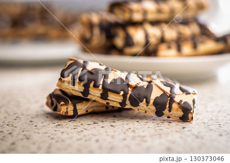 Sfogliatine glassate with chocolate. Italian crispy dessert on kitchen table. Sfogliatine glassate with chocolate. Italian crispy dessert on kitchen table. 130373046