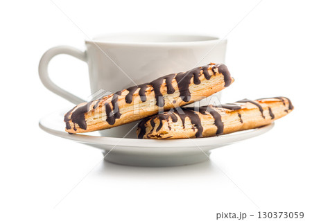 Sfogliatine glassate with chocolate. Italian crispy dessert and coffee cup isolated on white background. 130373059