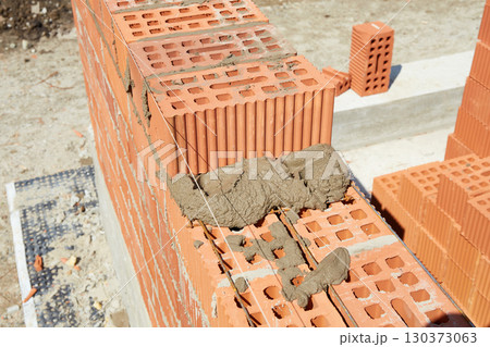 Brickwork construction in progress at a building site during daylight hours Brickwork construction in progress at a building site during daylight hours 130373063