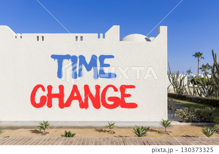 Time change symbol. Concept word Time change on beautiful white wall. Beautiful blue sky background. Business time change concept. Copy space. 130373325