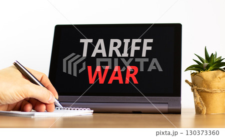Trade tariff war symbol. Concept word Tariff war on beautiful black tablet. Businessman's hand with pen. Calculator. Beautiful white background. Business trade tariff wars concept. Copy space. Trade tariff war symbol. Concept word Tariff war on beautiful black tablet. Businessman's hand with pen. Calculator. Beautiful white background. Business trade tariff wars concept. Copy space. 130373360