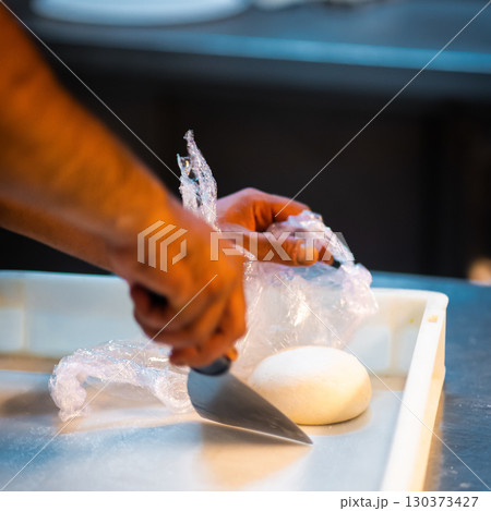 hands knead the raw pizza dough for pizza making hands knead the raw pizza dough for pizza making 130373427