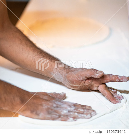 Cook hands kneading dough, piece of dough with white flour. close up on hands 130373441