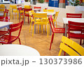 赤と黄色の椅子がたくさん並べられたカフェスペース 130373986