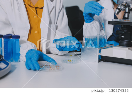 Collaboration, tablet or science with people in lab together for research or development. Innovation, tech and microscope with scientist team in clinical trial for planning or medical investigation 130374533