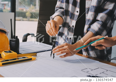 Construction and structure concept of engineer working drawing on blueprint meeting for project working with partner on model building and engineering tools in working site, construction concept. Construction and structure concept of engineer working drawing on blueprint meeting for project working with partner on model building and engineering tools in working site, construction concept. 130374547