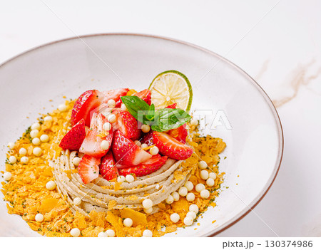 Fresh dessert with strawberries and lime on a white plate served in a restaurant 130374986