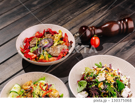 Delicious gourmet dishes served on wooden table in cozy dining setting 130375068