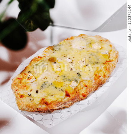 Delicious freshly baked flatbread topped with cheese and vegetables Delicious freshly baked flatbread topped with cheese and vegetables 130375144