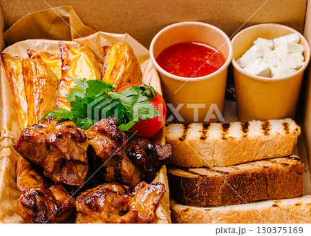 Delicious grilled meat platter with bread and sauces from local eatery 130375169