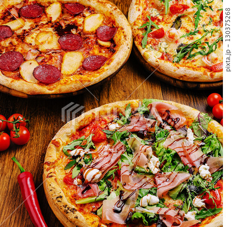 Delicious variety of pizzas with fresh toppings and vibrant colors displayed 130375268