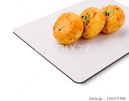 Delicious potato balls or cottage cheese pancakes served on a modern plate at a stylish eatery 130375366