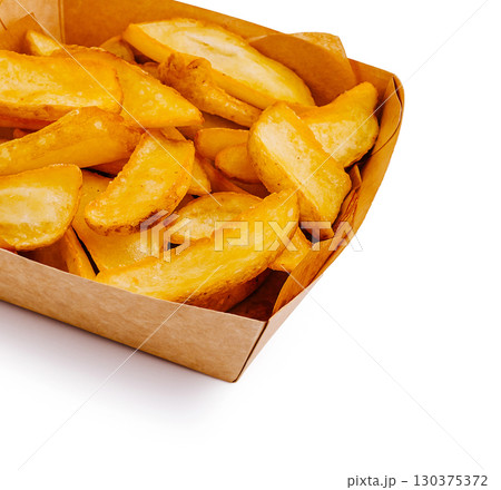 Crispy golden potato wedges served in a brown paper container 130375372