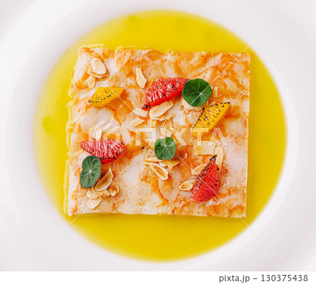 Delicious dessert presented on a white plate with bright garnishes and oil Delicious dessert presented on a white plate with bright garnishes and oil 130375438