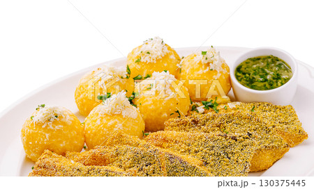 Crispy fish with golden balls served with green sauce and herbs Crispy fish with golden balls served with green sauce and herbs 130375445