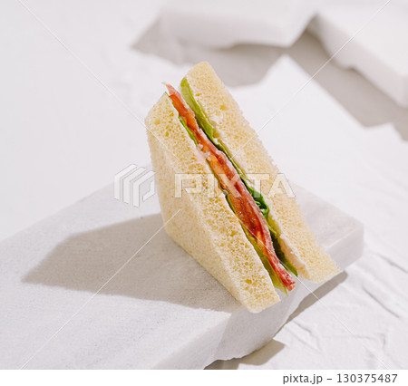 Delightful layered sandwich featuring fresh ingredients on a clean background 130375487
