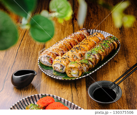 Delicious sushi rolls served on a wooden table in a cozy restaurant 130375506
