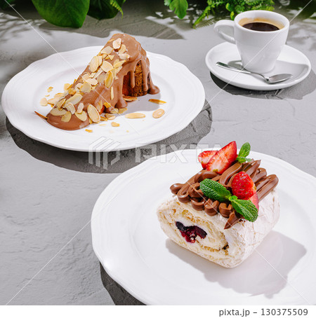Desserts on white plates with coffee in a cozy cafe setting 130375509