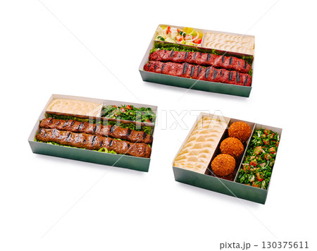 Delicious grilled kebabs and side dishes arranged in takeout boxes 130375611