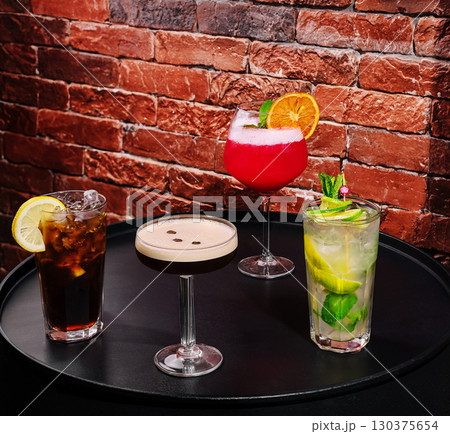 Vibrant assortment of cocktails served on a black table in a bar setting 130375654