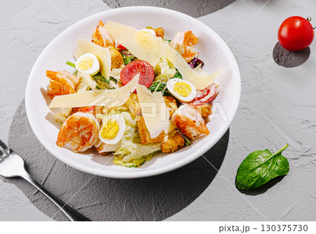 Delicious salad with shrimp, eggs, and vegetables served in a bowl 130375730