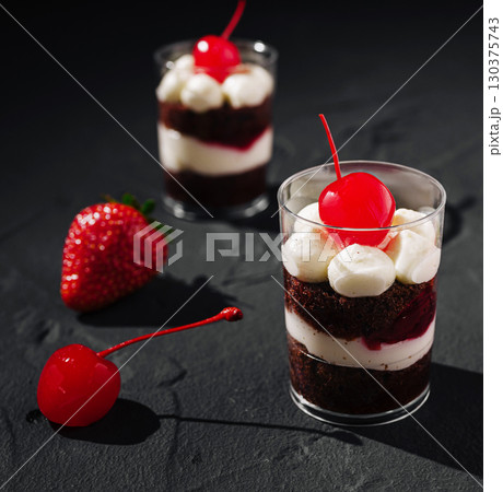 Delicious chocolate dessert cups with cherries and strawberries in focus 130375743