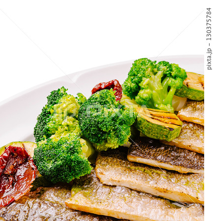 Delicious grilled fish with broccoli and sun-dried tomatoes on a plate Delicious grilled fish with broccoli and sun-dried tomatoes on a plate 130375784