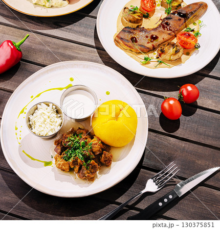 Delicious traditional meal served on a rustic wooden table at lunch 130375851
