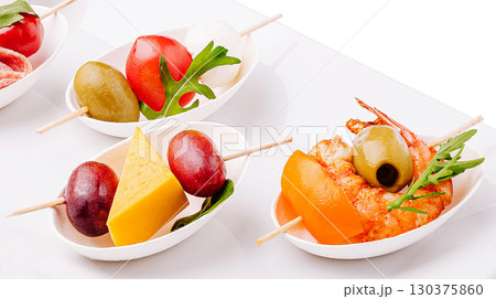 Colorful appetizer platter with skewered shrimp, olives, and vegetables Colorful appetizer platter with skewered shrimp, olives, and vegetables 130375860