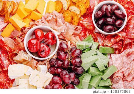 Colorful charcuterie board arrangement featuring various meats and cheeses Colorful charcuterie board arrangement featuring various meats and cheeses 130375862