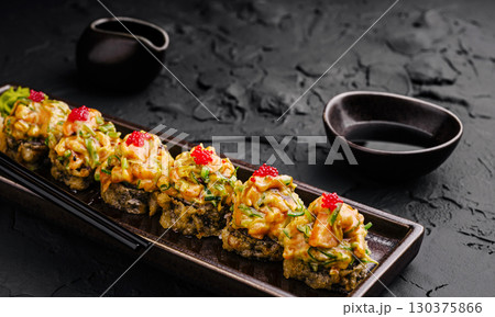 Sushi rolls with spicy mayo and roe served at a restaurant 130375866