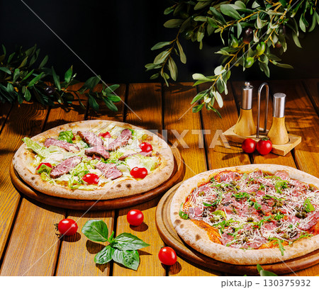 Delicious pizzas topped with fresh ingredients on a wooden table Delicious pizzas topped with fresh ingredients on a wooden table 130375932