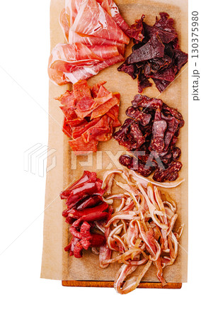 Artisanal cured meats displayed on a wooden board for a tasting experience 130375980