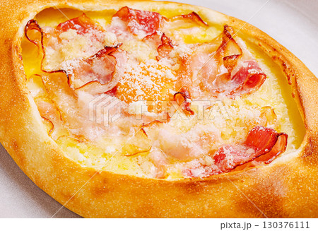 Delicious baked dish featuring ham and cheese on a golden crust Delicious baked dish featuring ham and cheese on a golden crust 130376111