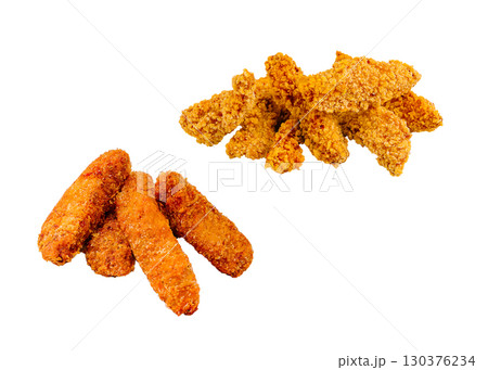 Crispy fried chicken tenders stacked on a white surface with golden color 130376234