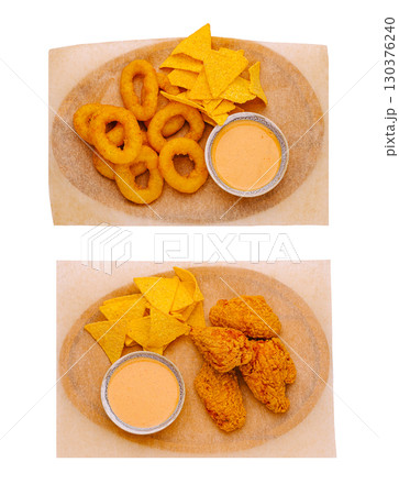 Crispy onion rings and fried chicken with dipping sauces on a platter Crispy onion rings and fried chicken with dipping sauces on a platter 130376240