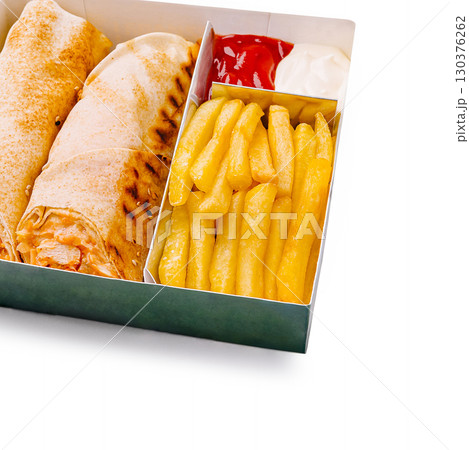 Delicious wrap and fries served in a takeout box with dips Delicious wrap and fries served in a takeout box with dips 130376262