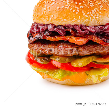 Juicy burger with toppings served on a sesame seed bun in a bright setting 130376333