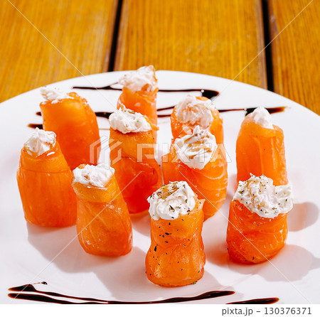 Creative sushi rolls made with smoked salmon and cream cheese on a white plate Creative sushi rolls made with smoked salmon and cream cheese on a white plate 130376371